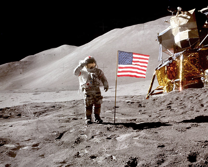 NASA photo of Apollo 15 commander David Scott saluting the camera while standing near the Lunar Module and the American Flag on the Moon.